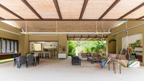 Amplia sala de estar integrada con cocina, comedor y zona de descanso con sillas colgantes.