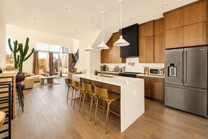 A modern kitchen with a central island, stainless steel appliances, and wooden cabinetry.