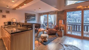 A spacious living area with a large window, a fireplace, and a cozy seating arrangement. - Belvédère du Brévent - Welkeys (Chamonix-Mont-Blanc)