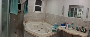 Bathroom features a bathtub, glass shower enclosure, and vanity with sink and countertop.