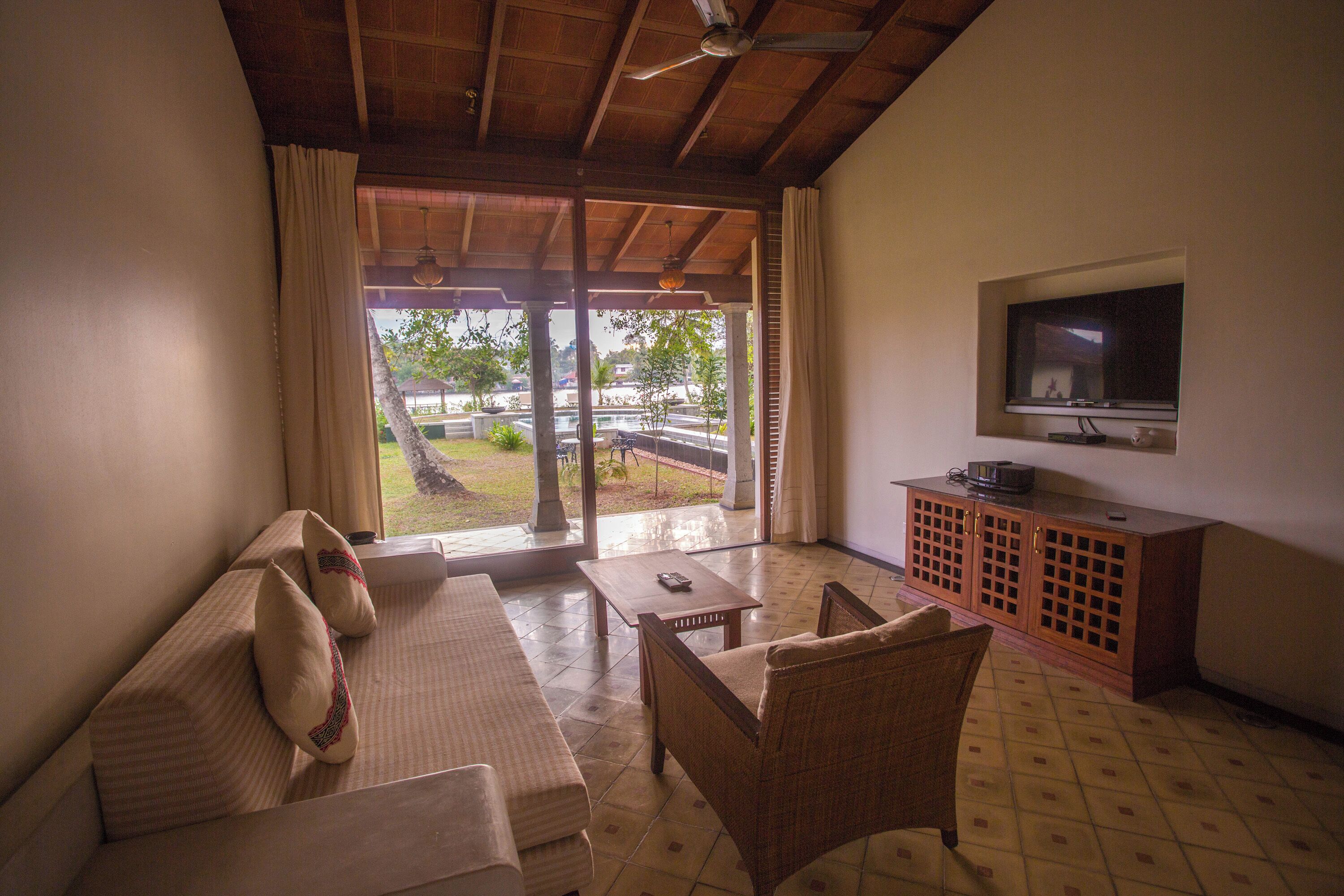 A living room with a sofa, armchair, and television on a wooden cabinet.