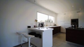 Een koelkast, een oven, een vaatwasser, kookgerei, borden en bestek