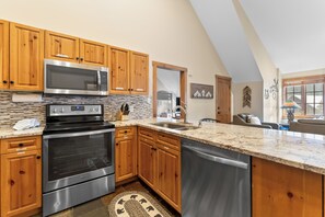 A kitchen with wooden cabinets, stainless steel appliances, a granite countertop, and a tiled backsplash. - Es8629-2 (Keystone)