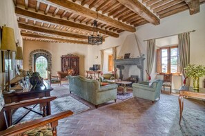 Un intérieur rustique avec des poutres apparentes, une cheminée et des meubles traditionnels.