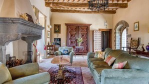 Un salon spacieux doté d’une cheminée, d’une grande porte en bois et d’un coin salon confortable.
