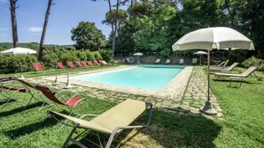 Une piscine avec des chaises longues et des parasols.