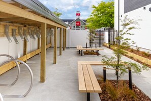 Enjoy a peaceful outdoor space with a covered seating area, metal handrails, and benches.