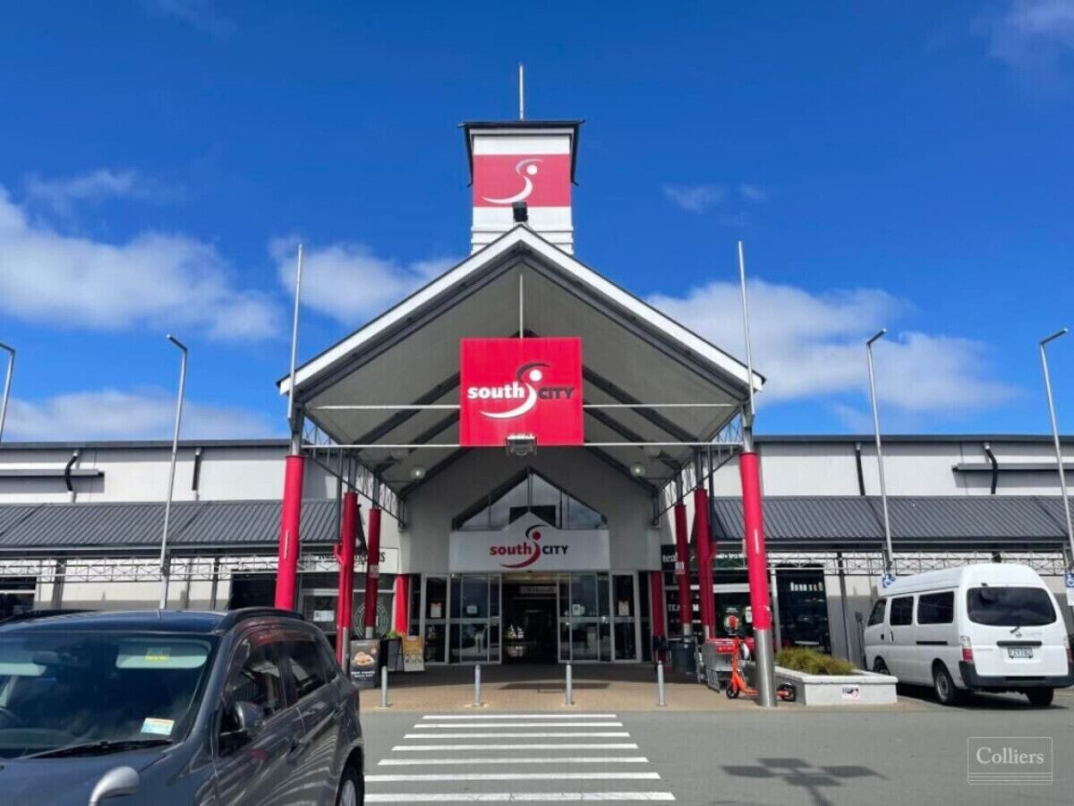 A South City store with a prominent red and white sign, a covered entrance, and a clear blue sky.