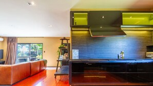 Een moderne keuken met een zwart aanrecht, een inbouwfornuis en een achterwand met groene verlichting.