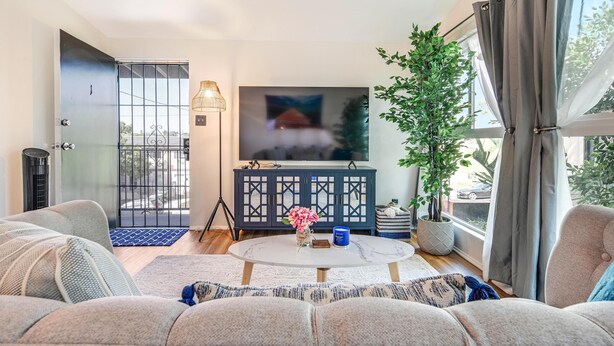 Ein modernes Wohnzimmer mit einer Couch, einem Couchtisch und einem Fernseher.
