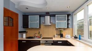 Una cocina compacta con armarios oscuros, un horno empotrado y una ventana que ofrece vistas al exterior.