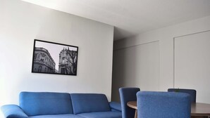 A room with a blue sofa, a dining table with chairs, and a framed picture on the wall. - depa 205 · Department in the Historic Center 205 (San Luis Potosí)