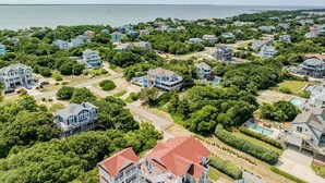 Un quartier résidentiel situé sur la côte, où les maisons sont entourées de verdure et offrent une vue sur la mer.