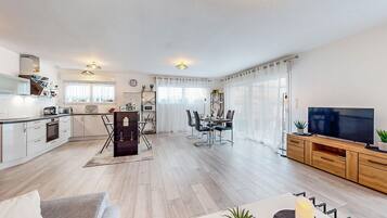 Un appartement moderne comprenant une cuisine, un coin repas et un salon.