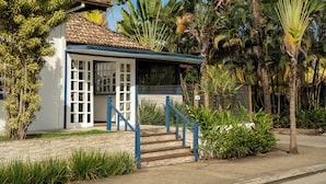 A small, single-story building with a tiled roof and a porch with blue railings. - Casa Poema Paraty (Paraty)