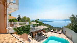 A poolside area with a view of the sea, outdoor furniture, and a stone staircase. - Villa Anastasia: Amazing views of Kerasia, private pool, WiFi, A/C (Sinies)