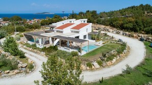 A modern villa with a swimming pool, solar panels, and a view of the sea. - Escape to Aristi Dio – where nature meets luxury in Halkidiki (Olympiada)