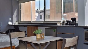 Une cuisine compacte avec une fenêtre, un petit réfrigérateur et une machine à café.