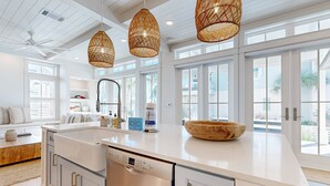Una cocina moderna con armarios blancos, una isla grande y un lavavajillas integrado.