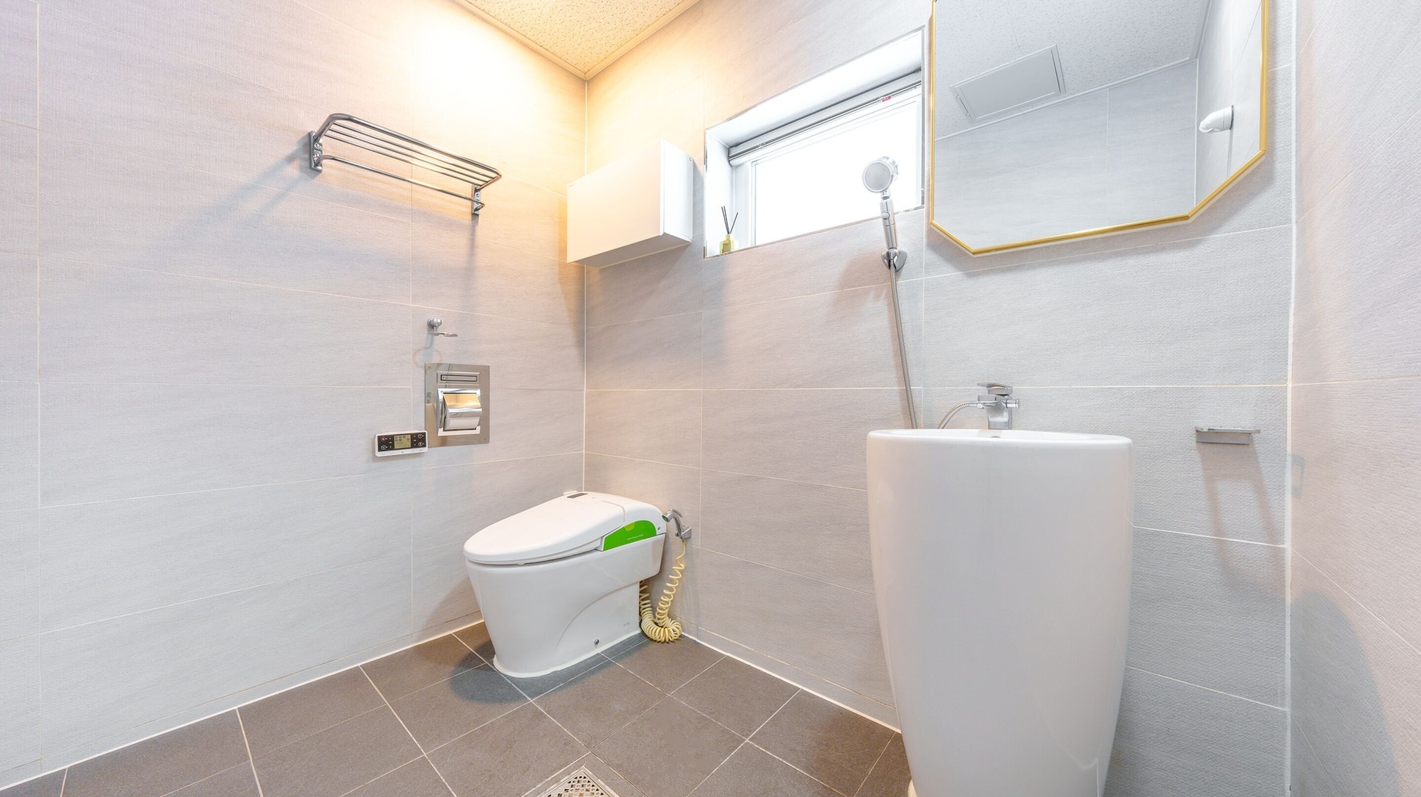 Une salle de bain moderne équipée de toilettes, d’un bidet et d’un lavabo.