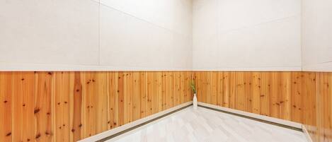 Habitación con la mitad inferior de madera y la mitad superior de color blanco, y un piso con estampado de espiga.