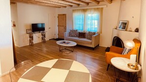 A cozy living room with a sofa, television, and a fireplace. - Lovely Home on Museum Hill-walk to Plaza/Canyon Rd (Santa Fe)