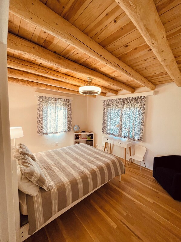 A bedroom with a bed, a desk, and a chair.