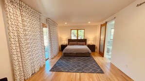 A modern bedroom with a large bed, wooden flooring, and a patterned rug. - Lovely Home on Museum Hill-walk to Plaza/Canyon Rd (Santa Fe)