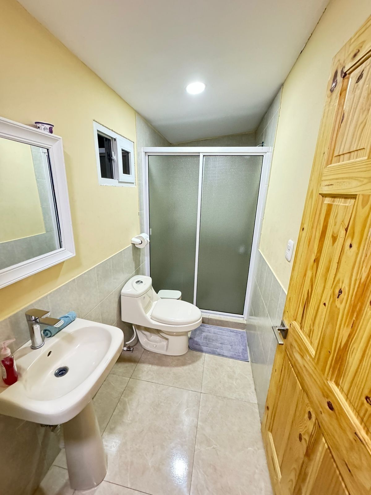 A bathroom with a sink, toilet, and shower area.