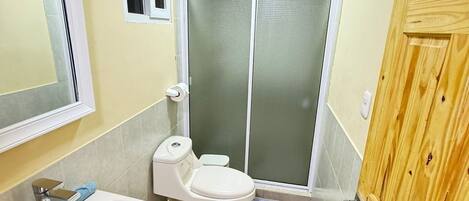 A bathroom with a sink, toilet, and shower area.