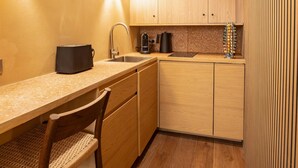 A compact kitchen with wooden cabinets, a countertop, a sink, and a chair. - Charming Studio With A/C - 2P - Center St Tropez (Saint-Tropez)