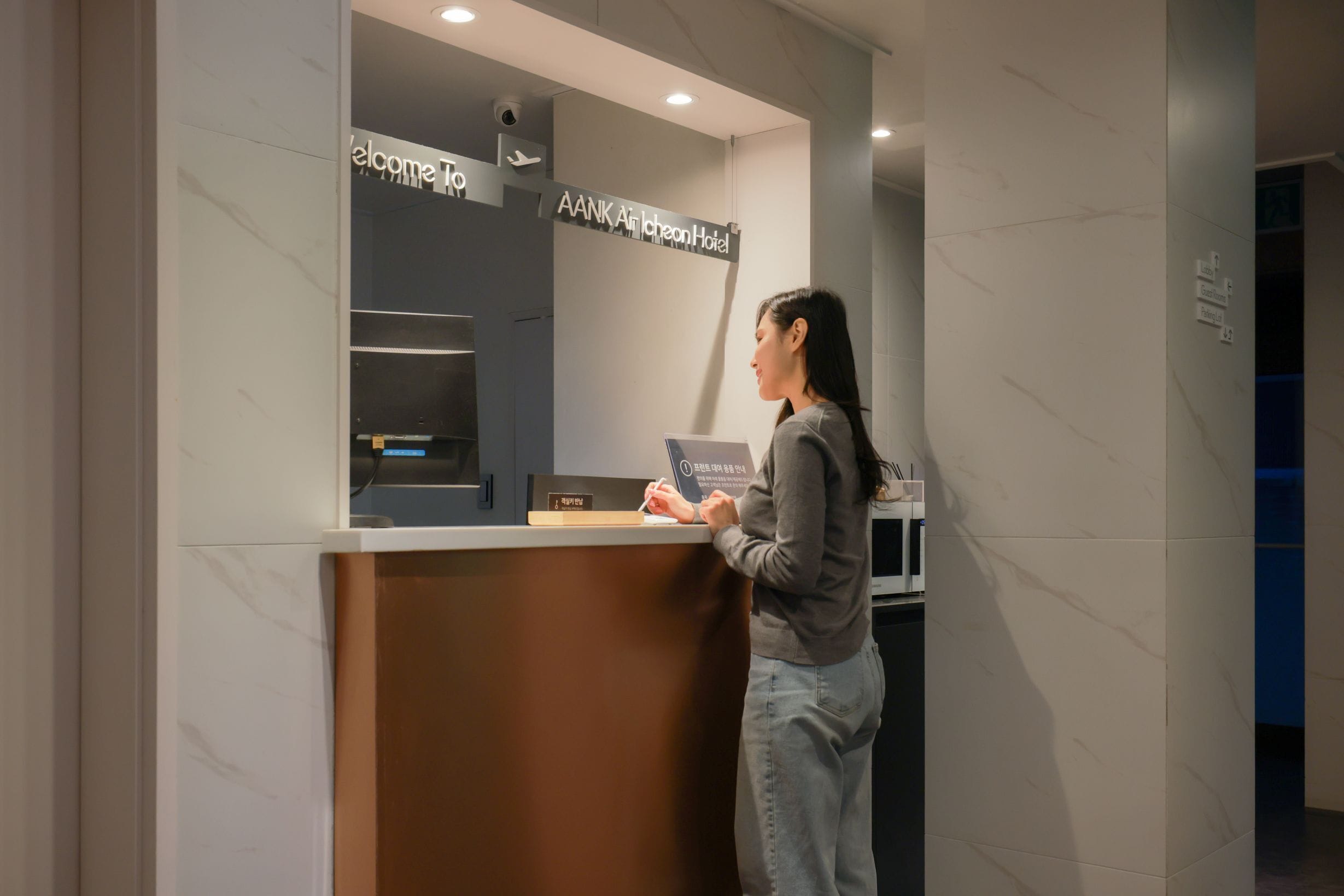 A reception desk with a sign that reads "Welcome To AANK Aircheon Hotel."