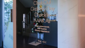 Uma área de recepção com uma árvore de Natal e uma placa que diz "Check Out Ordinary Day Check In AANK Air".