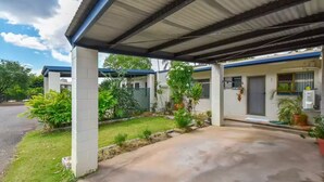 A residential property with a covered porch, a small garden, and a paved driveway.