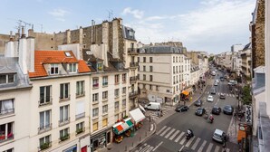 A street view with buildings, a crosswalk, and vehicles. - Serene Apartment - 1br/4p - Place de la Bastille (Paris)