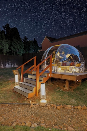 A dome structure with a staircase leading to it, set against a night sky with stars.