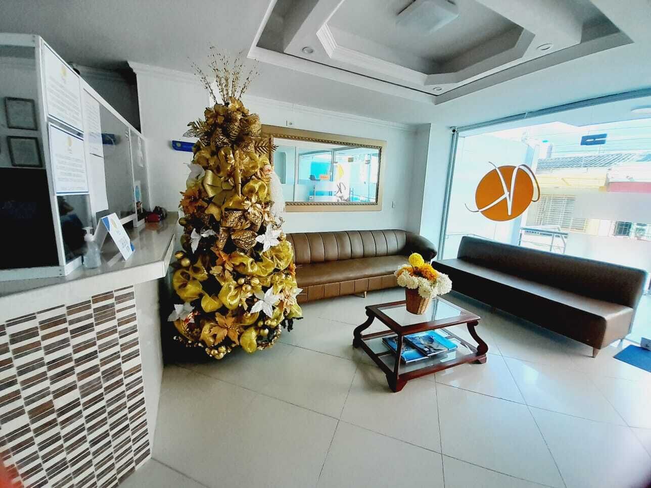 Una sala de estar moderna con un árbol de Navidad grande, un sofá y una mesa de centro.