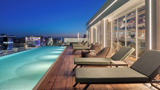 A rooftop pool area with lounge chairs and a bar area. - Hilton Garden Inn Athens Syggrou Avenue (Kallithea)