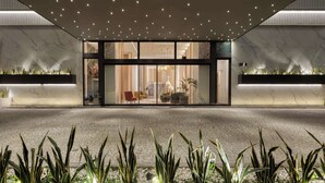 A modern hotel entrance with a marble facade, glass doors, and a starry ceiling. - Hilton Garden Inn Athens Syggrou Avenue (Kallithea)