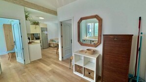 Une pièce spacieuse avec un plancher en bois, un mur blanc, une armoire en bois et un miroir.