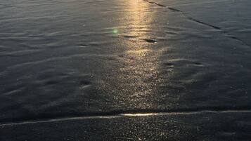 Un lago ghiacciato con il sole che si riflette sulla superficie.