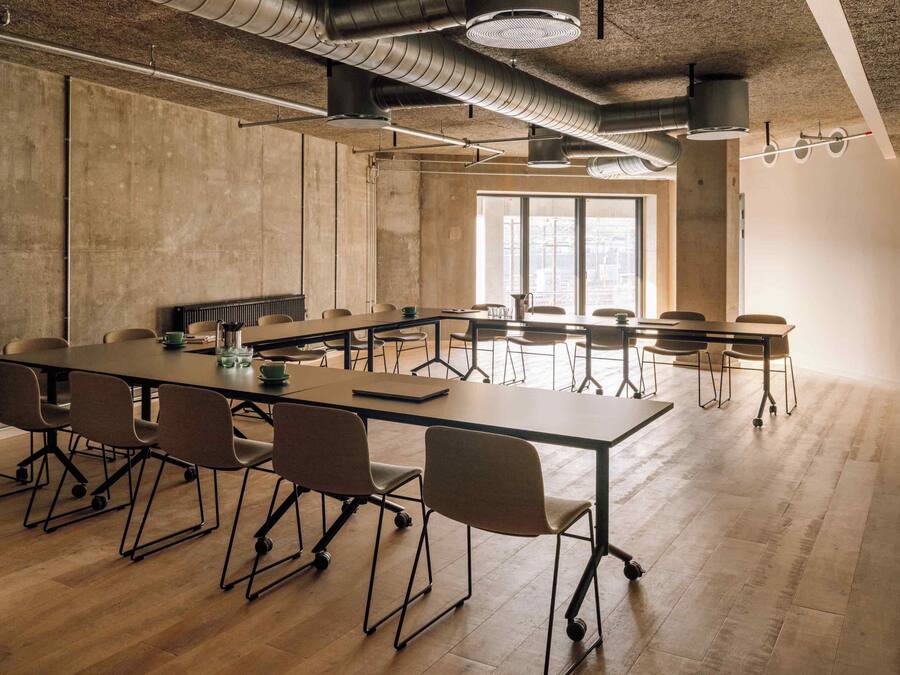 Une salle de conférence avec une longue table, des chaises et une grande fenêtre.