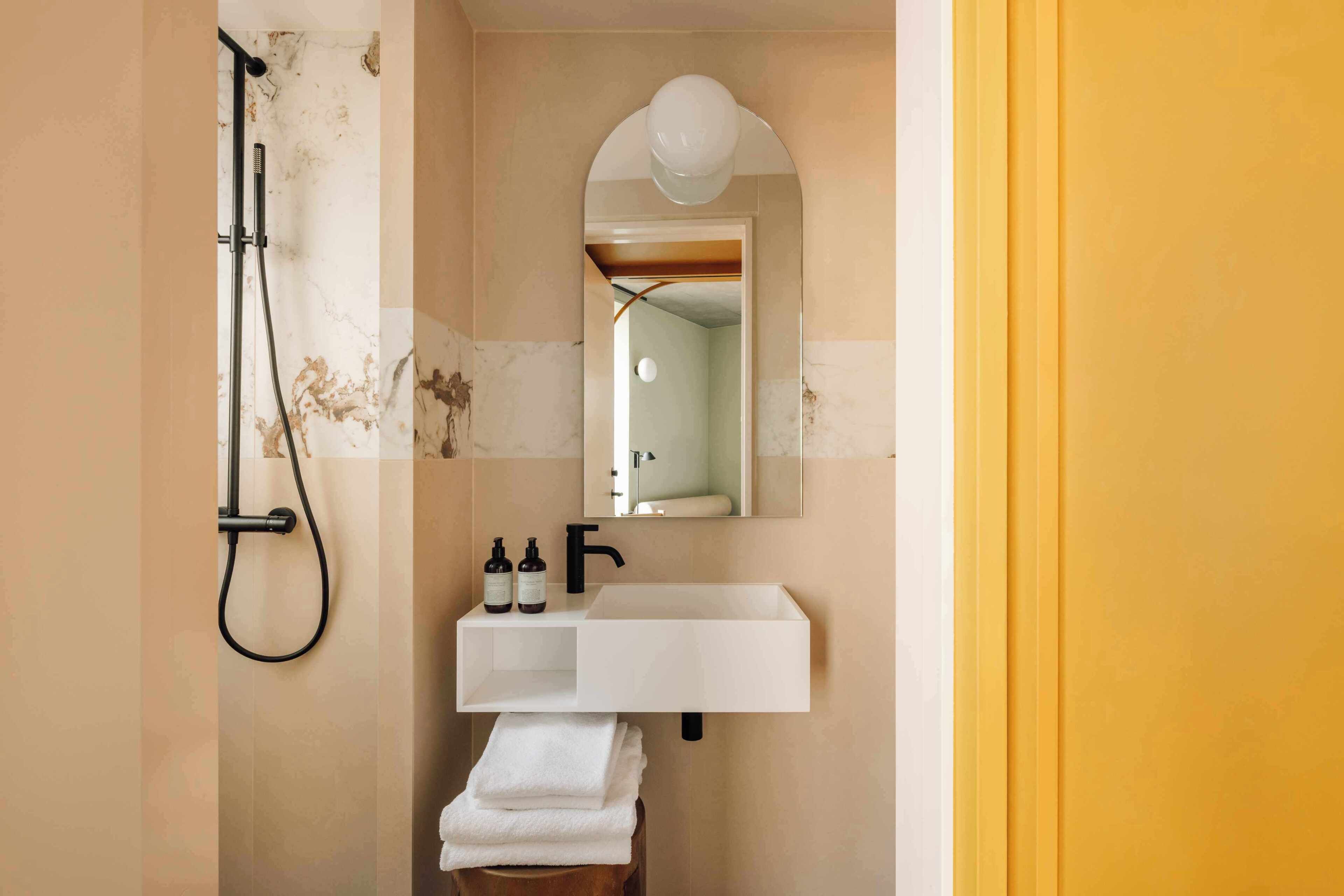 A bathroom with a white sink, a mirror, and a shower.