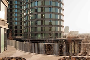 A modern building with a curved facade, multiple windows, and a pedestrian walkway. - Locke Copenhagen (Copenhagen)