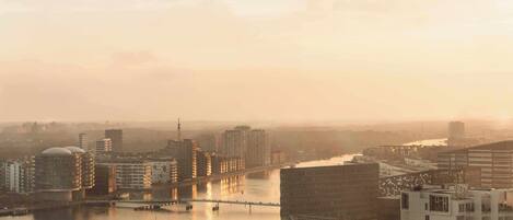 A cityscape with high-rise buildings, a river, and a bridge.