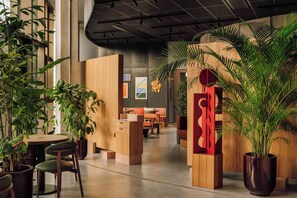 Ein modernes Interieur mit einer Rezeption, einer Sitzecke und Blumentöpfen.
