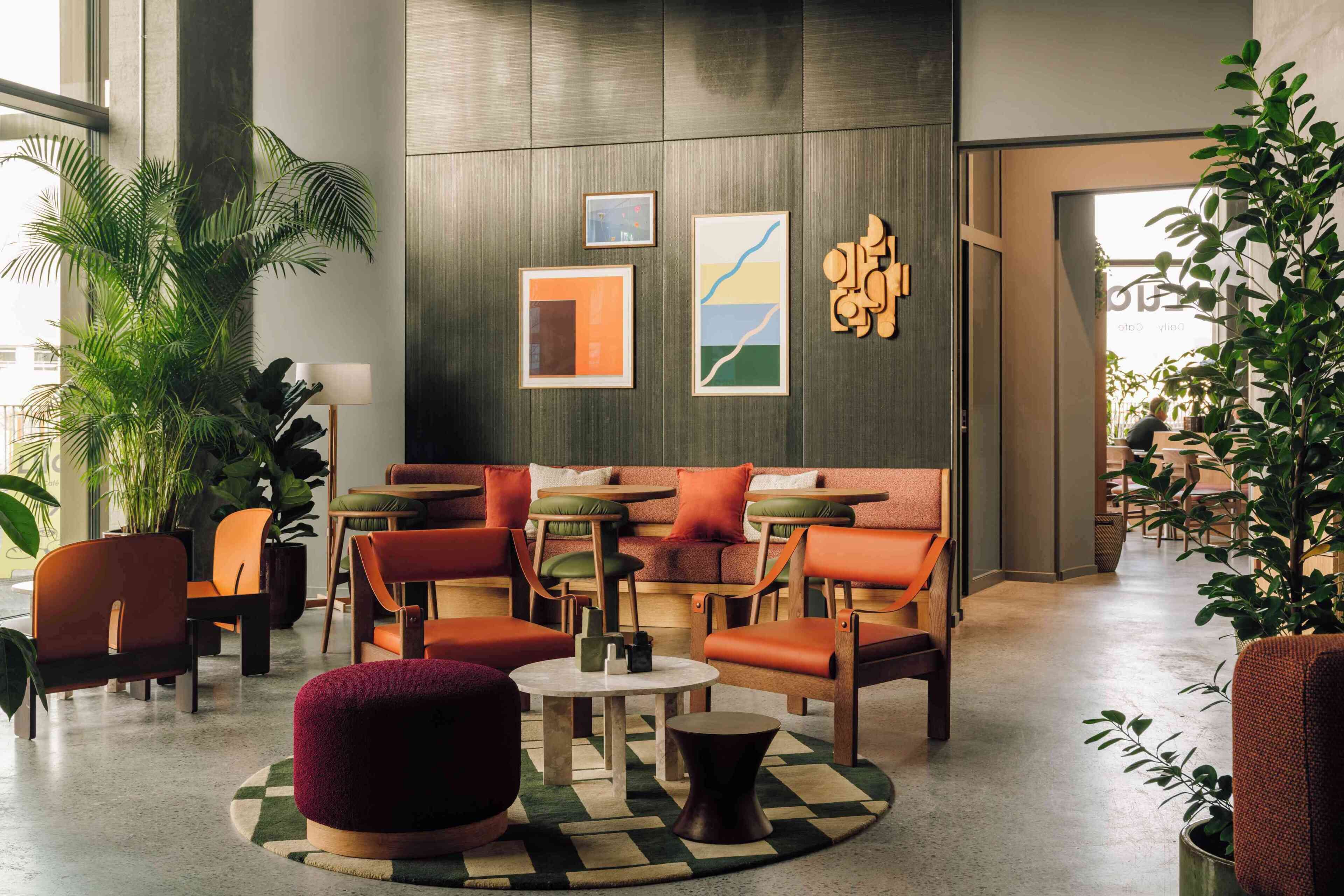 A modern lounge area with seating, tables, and artwork on the walls.