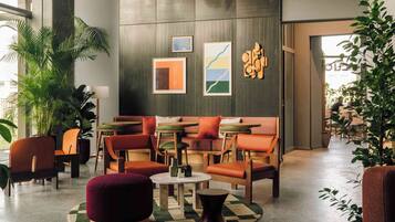 A modern lounge area with seating, tables, and artwork on the walls.