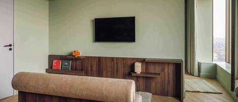 Una habitación moderna con un banco de madera, un televisor de pantalla plana en la pared y una ventana con vistas.