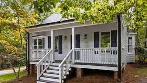 A two-story house with a front porch, a staircase, and a brick foundation. - NEW Fully Remodeled Home w/ Office Workspace, Patio, 3 Bed, 2 Bath (Holly Springs)